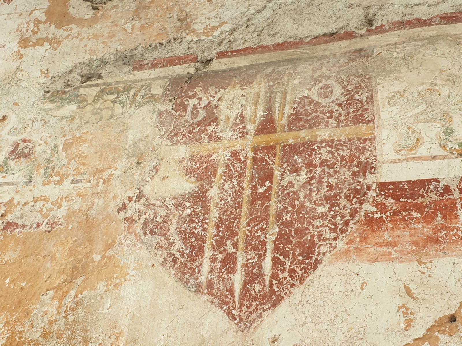 Neben der Eingangstür befindet sich das Wappen der Familie Oldreghini. Es zeigt eine Axt, gekreuzt von drei Pfeilen, in den Ecken die Buchstaben B und O